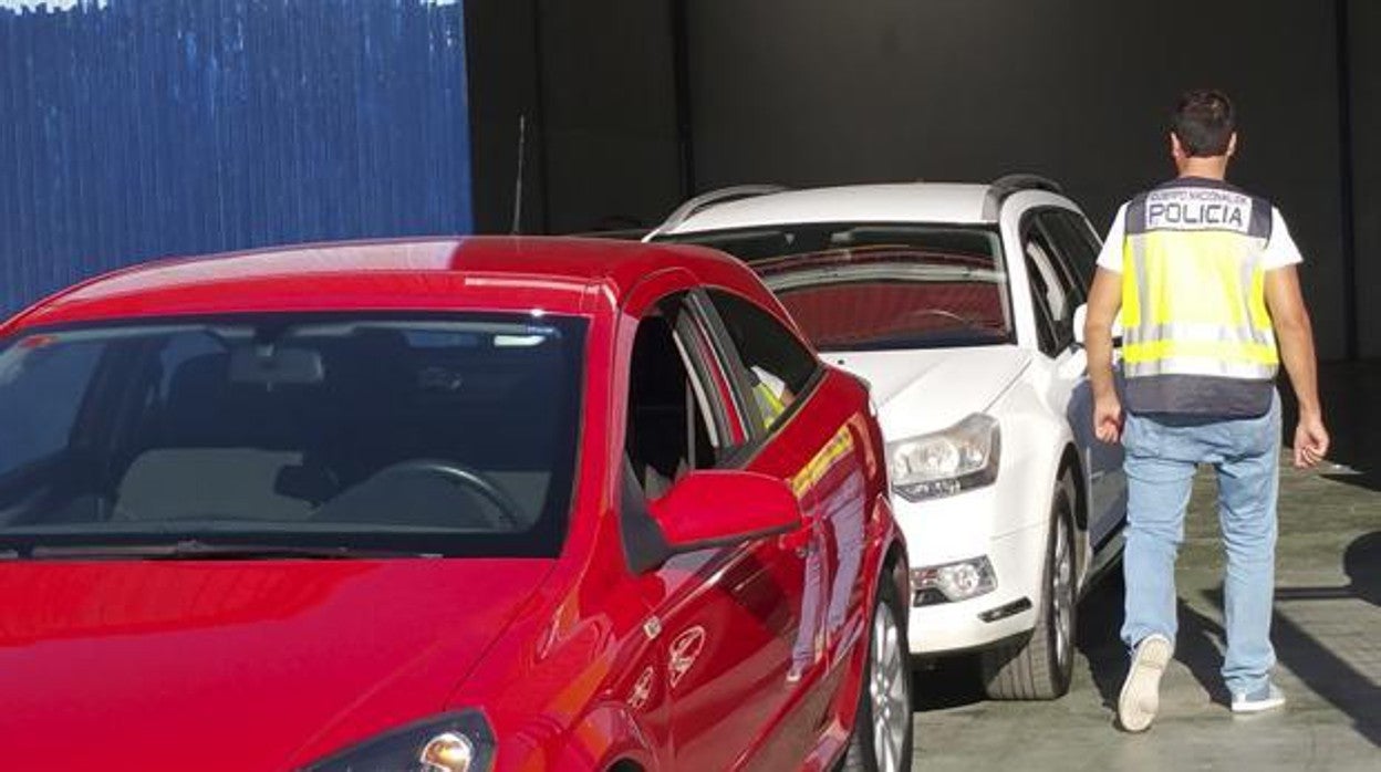 Un agente policial junto a varios vehículos en una imagen de archivo