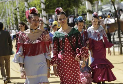 Un grupo de jóvenes vestodas de flamenca por el Real
