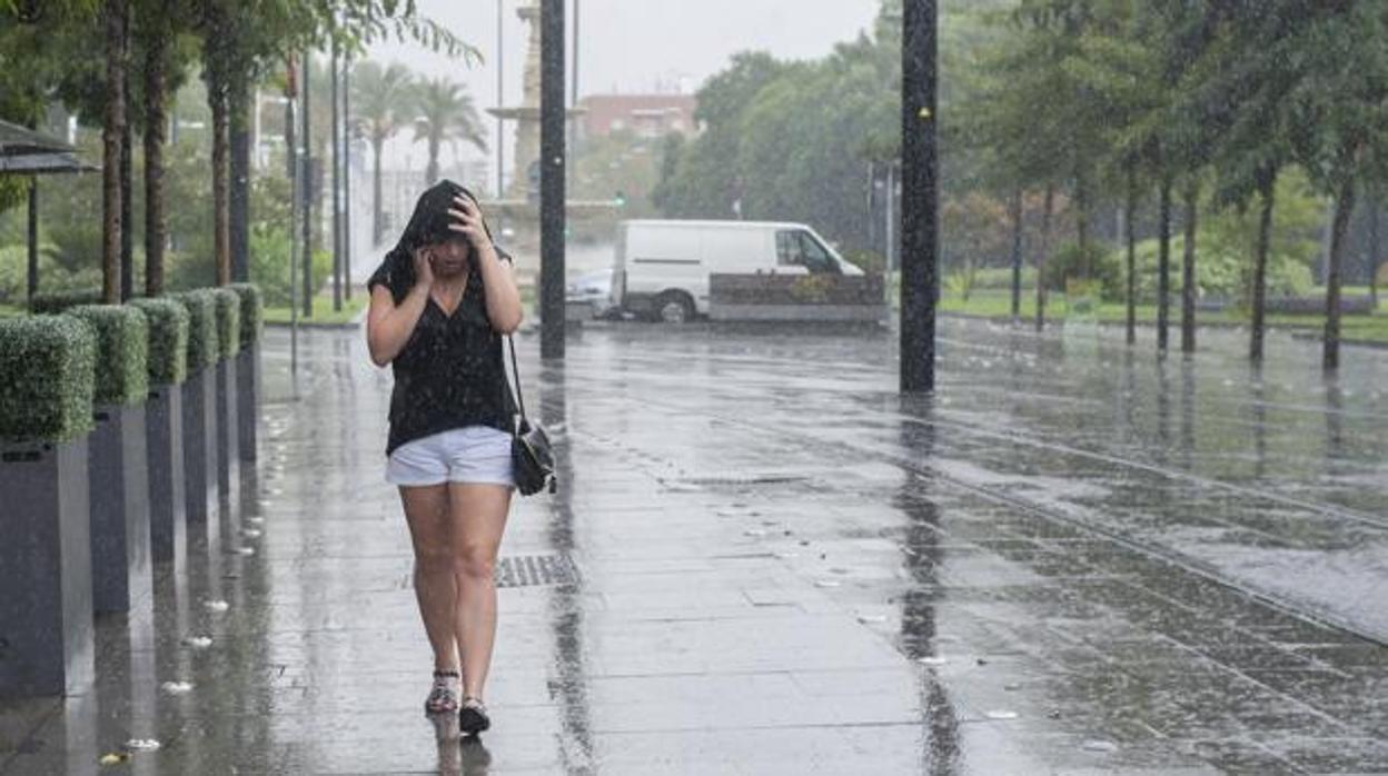 Una joven se protege de la lluvia en verano