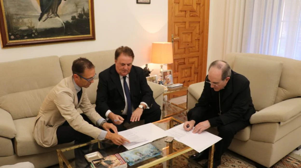 Monseñor Asenjo firmando con Gonzále-Alorda y Martín Serrano