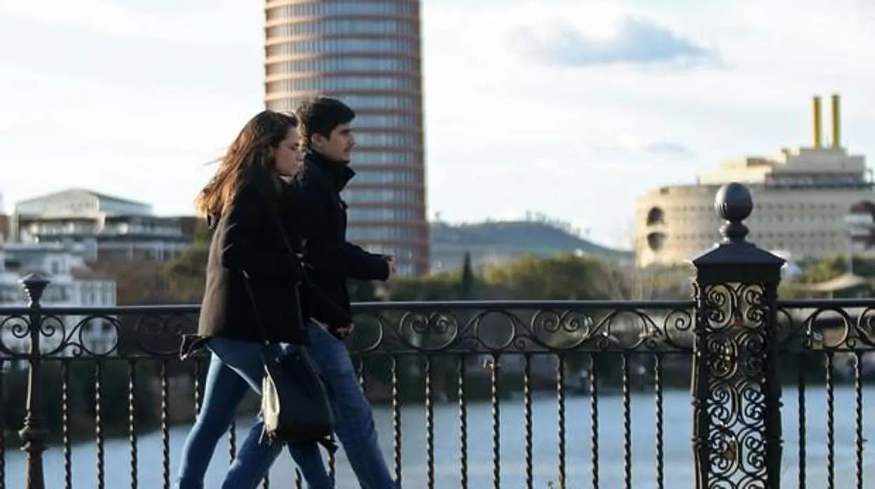 Una pareja pasea por el puente de Triana en Sevilla