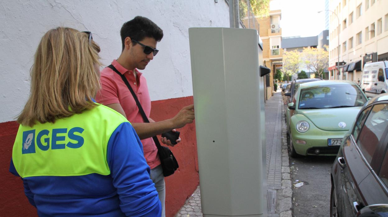 Una empleada de la zona azul asiste a un usuario en Nervión