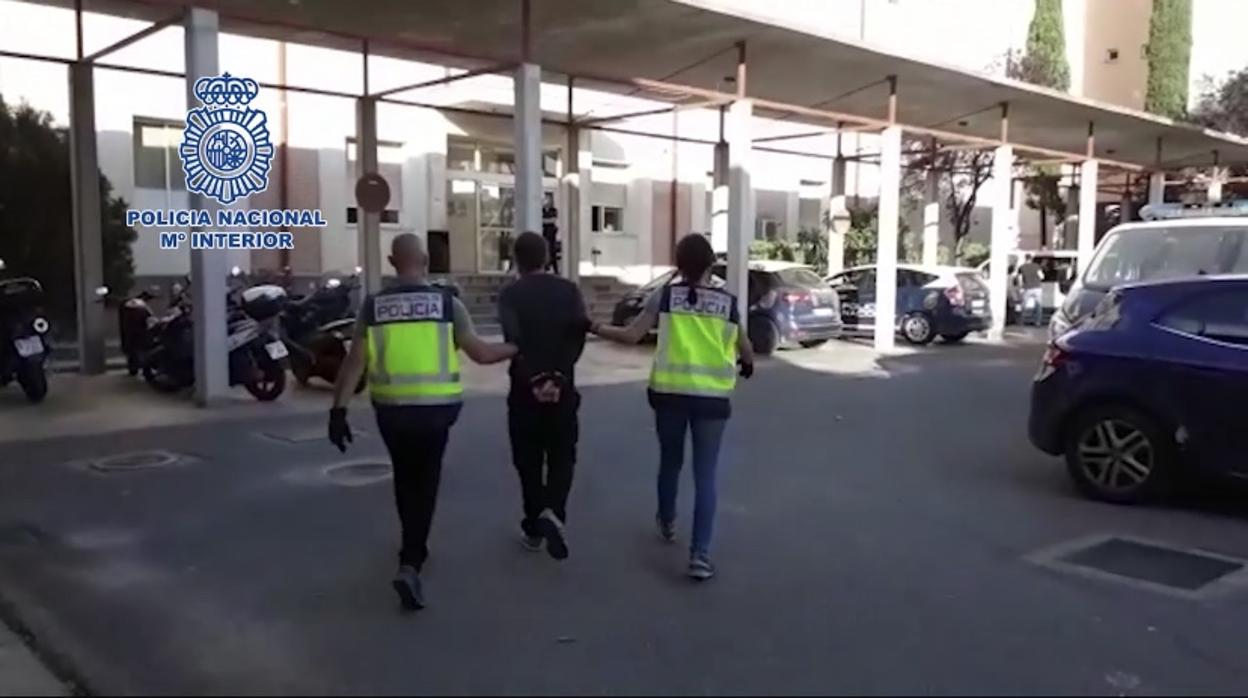 Dos agentes de la Policía Nacional conducen al detenido a dependencias policiales