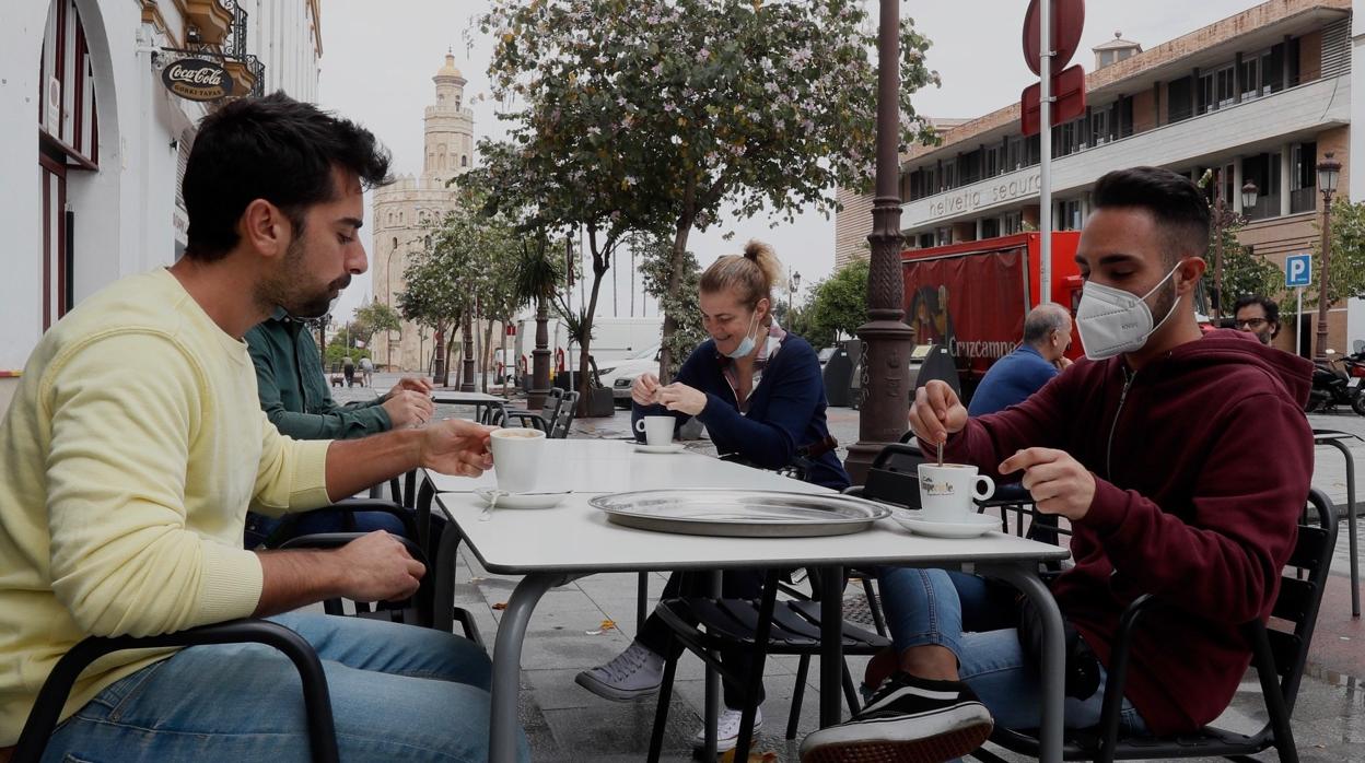 Dos jóvenes desayunando en una calle de Sevilla