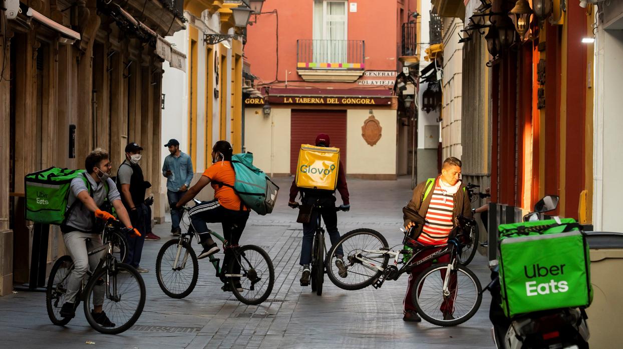 Repartidores de comida a domicilio, concentrados con sus bicicletas en una céntrica calle de Sevilla