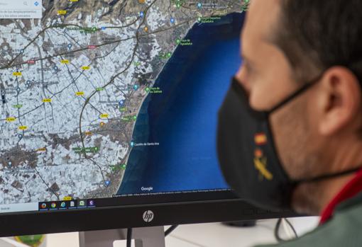 Un agente revisa la información de un mapa de la costa