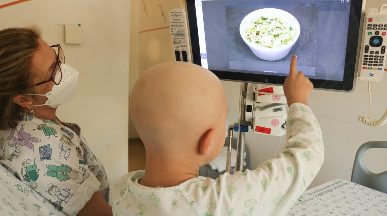 Un paciente del área de Oncología Infantil del Virgen del Rocío visualiza los diferentes platos que puede elegir