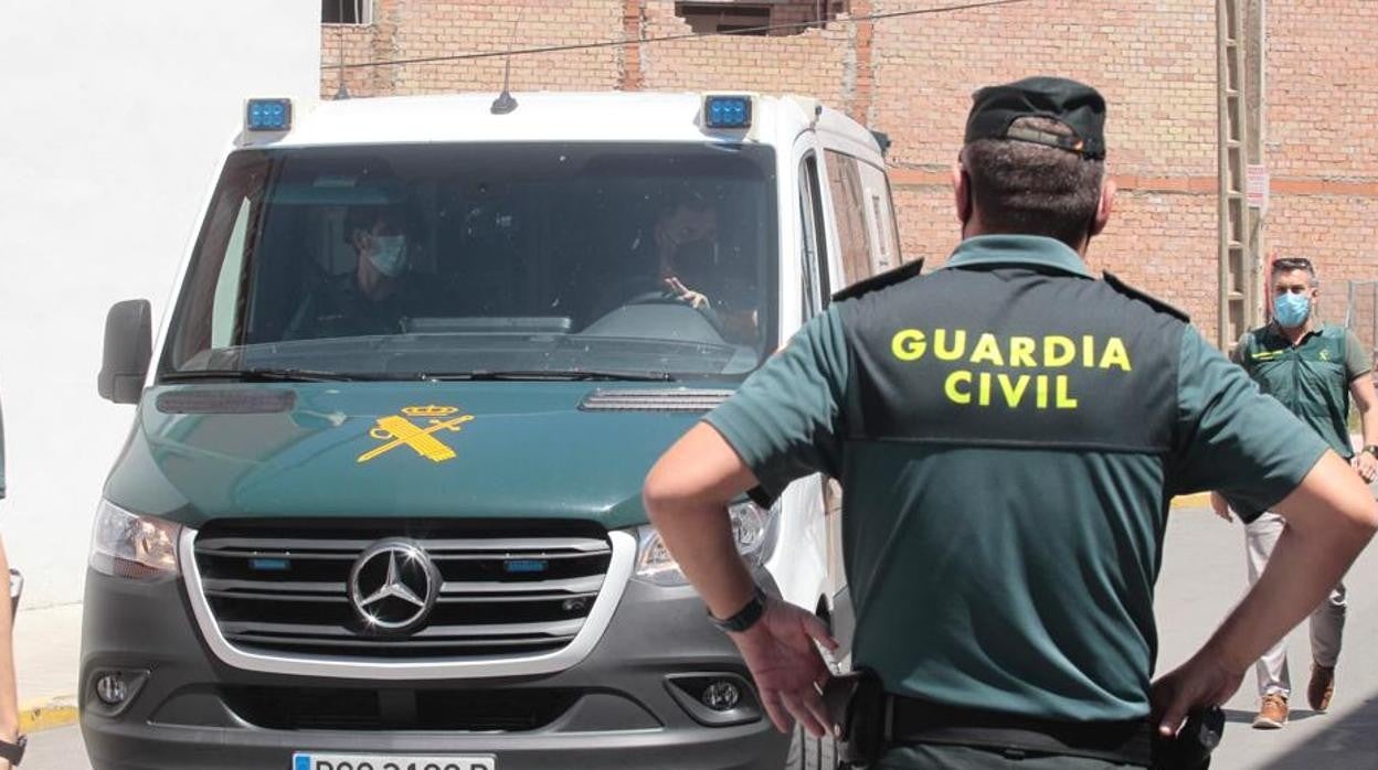 Agentes de la Guardia Civil esperan al detenido, que ha llegado en un furgón al piso de Estepa
