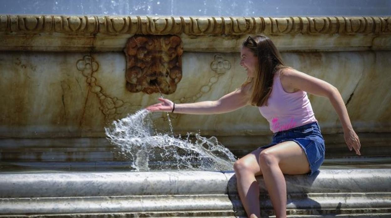 Una turista se refresca en la Plaza de España