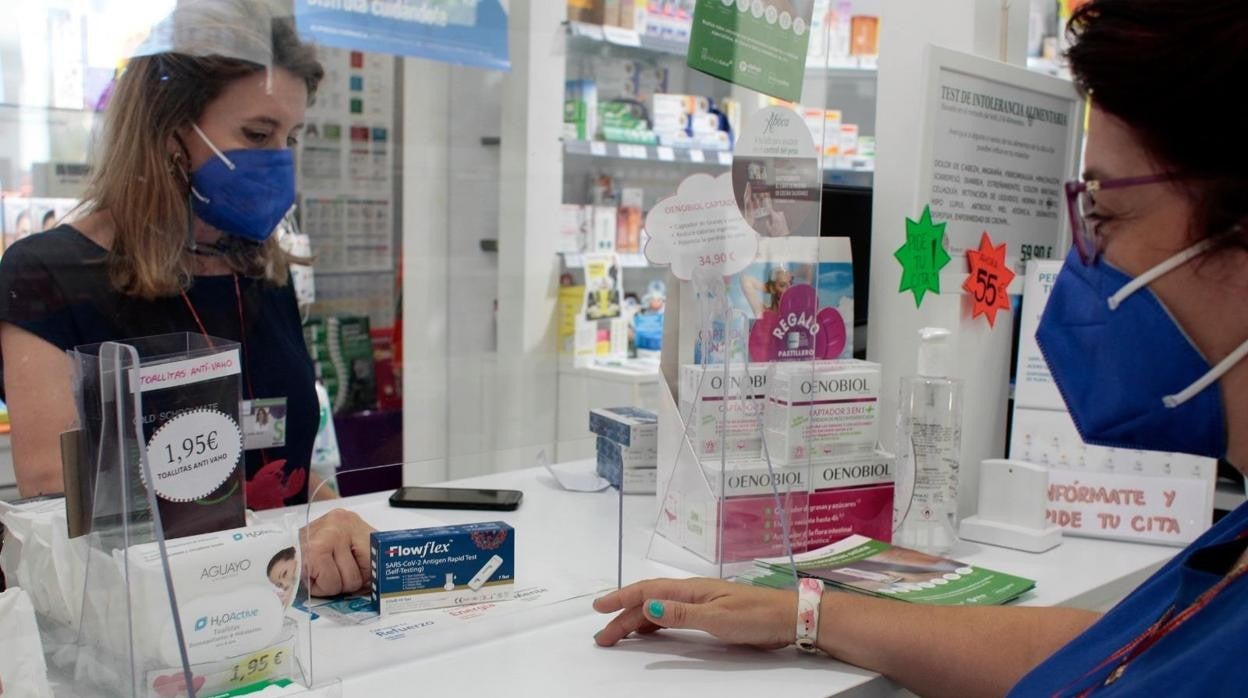 Una farmacia vendiendo test de antígenos en Sevilla