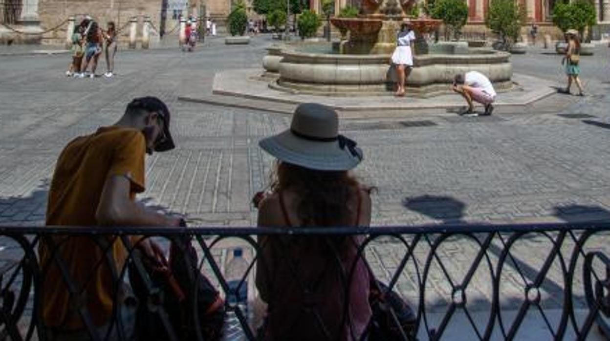Turistas a la sombra en la plaza de la Virgen de los Reyes