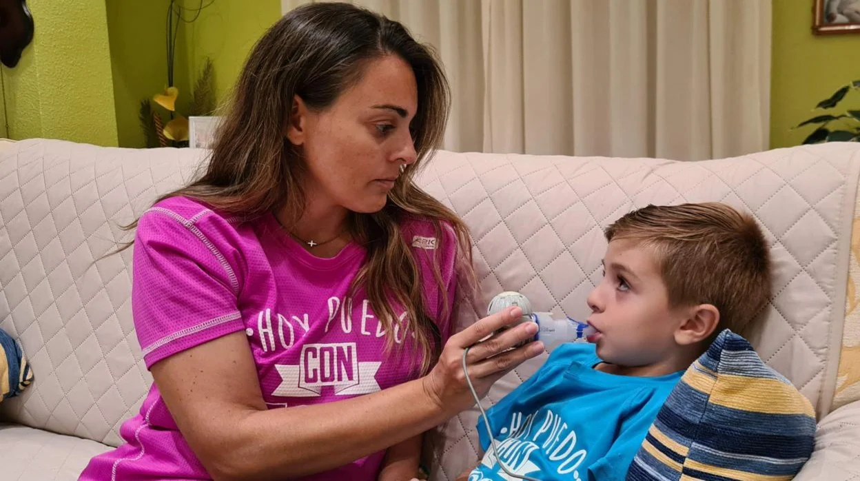 La sevillana Rocio Espinosa da a su hijo Alejandro, de 6 años, una medicina para la fibrosis quística