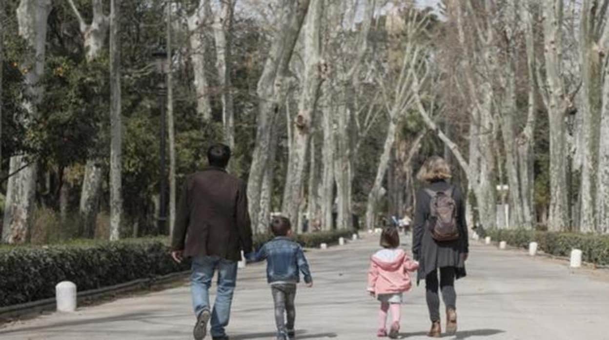 Una familia con niños pasea por el Parque de María Luisa