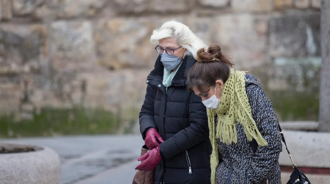 Dos mujeres caminan junto al Alcázar de Sevilla este domingo por la mañana