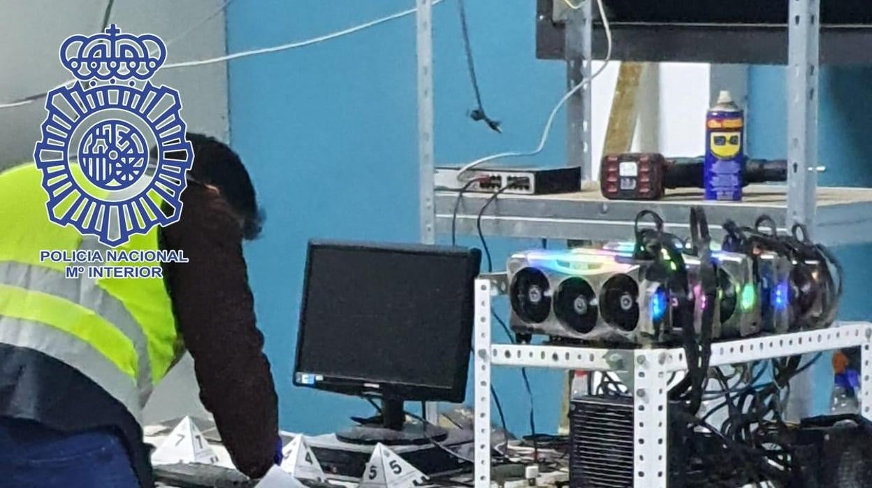 Un agente revisa los equipos informáticos de la granja descubierta en Santiponce