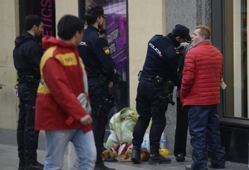 La Policía cacheando a un individuo en la calle