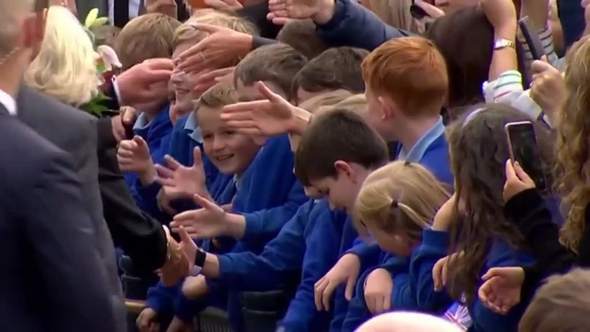 Niños le dan la mano emocionados a Carlos III