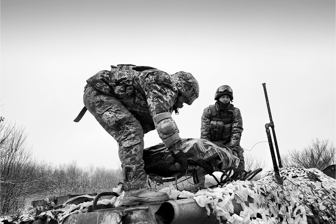 Donbas - Ucrania: Dos soldados ucranianos bajan el cadaver de un compañero fallecido en combate en la morgue de un centro de estabilización del frente en el Este de Ucrania.
