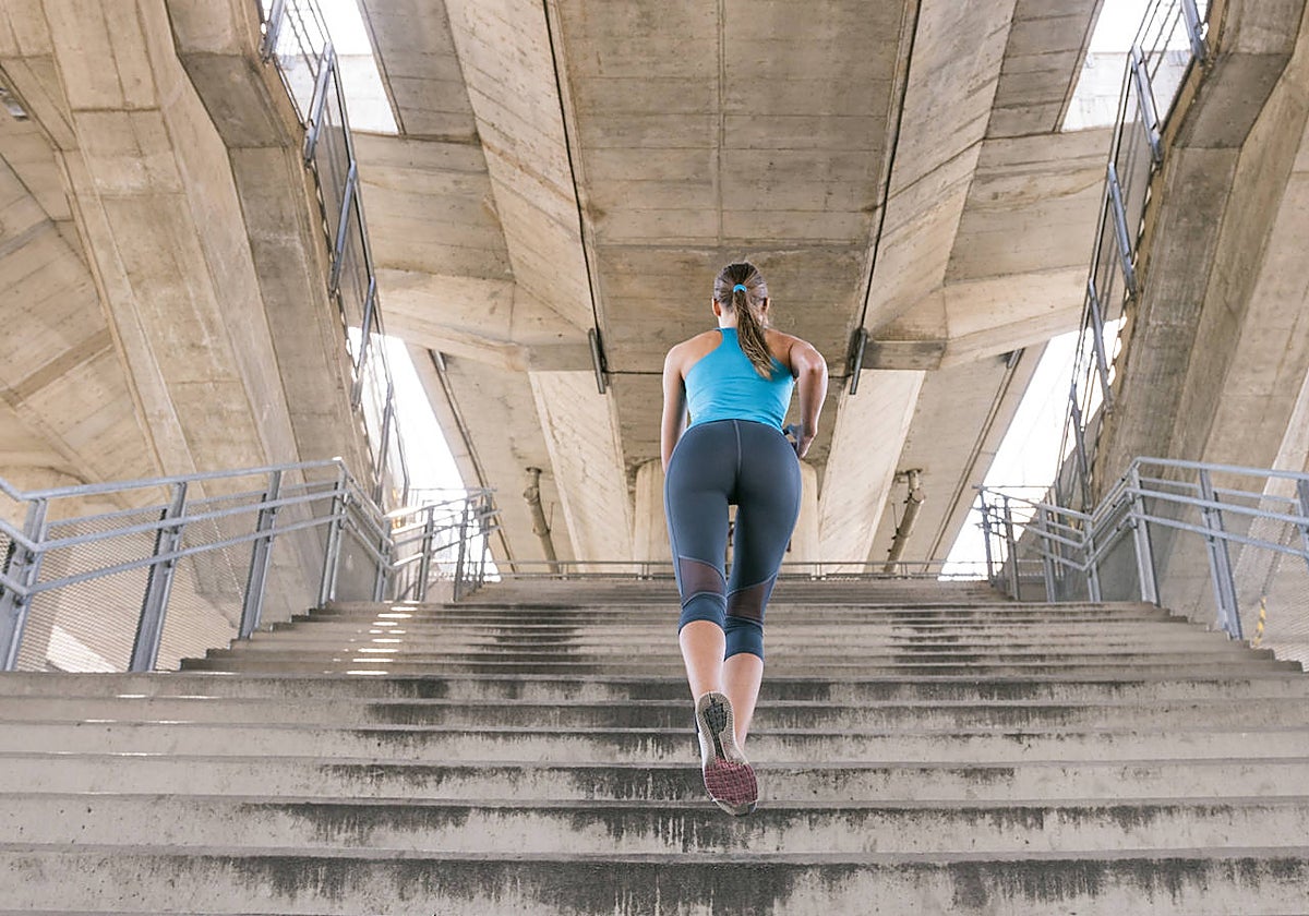 Una mujer, subiendo escaleras.