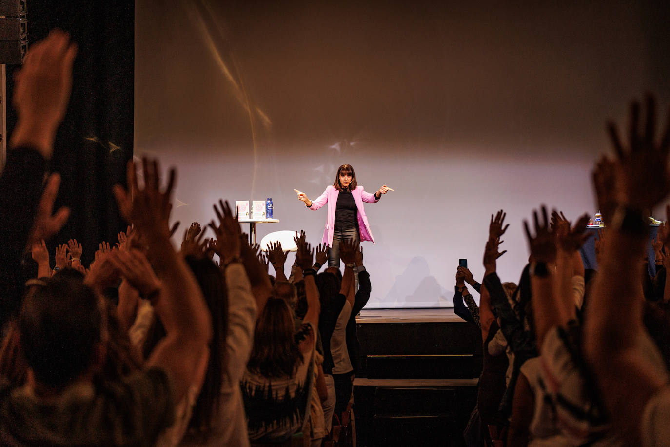 Raquel Alcolea, periodista de ABC Bienestar, fue maestra de ceremonias del evento 'Adiós a la inflamación' en el Teatro Alcázar de Madrid el pasado 5 de octubre y durante la presentación invitó a los asistentes a saludar a Sandra Moñino con una "ola que va y viene y por el camino se entretiene" para simular el efecto que puede causar la inflamación en el cuerpo. 