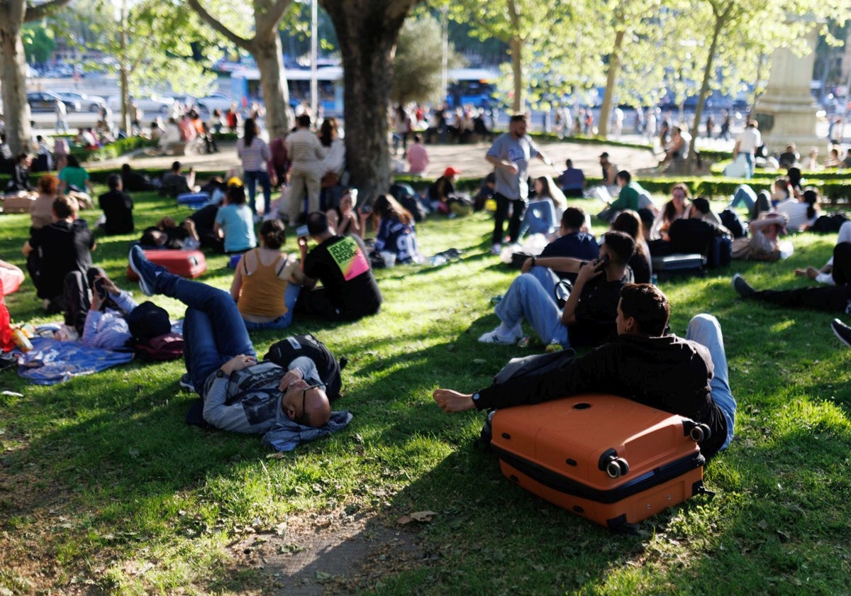 Varias personas en un parque, esperando a poder viajar durante el apagón en Madrid.