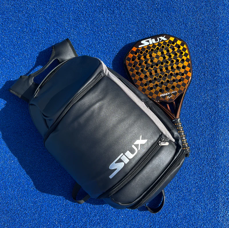 Pura potencia con estilo urbano. La Siux Fenix Pro es una pala de alto rendimiento diseñada para jugadores agresivos que buscan máxima pegada y efecto. Su forma diamante, balance alto y tacto duro la convierten en un arma letal en ataque. Se complementa con la mochila Siux The Book, de diseño minimalista y compartimentos inteligentes, ideal para moverte con ligereza sin renunciar a espacio ni elegancia. De 354 euros a 265 euros.