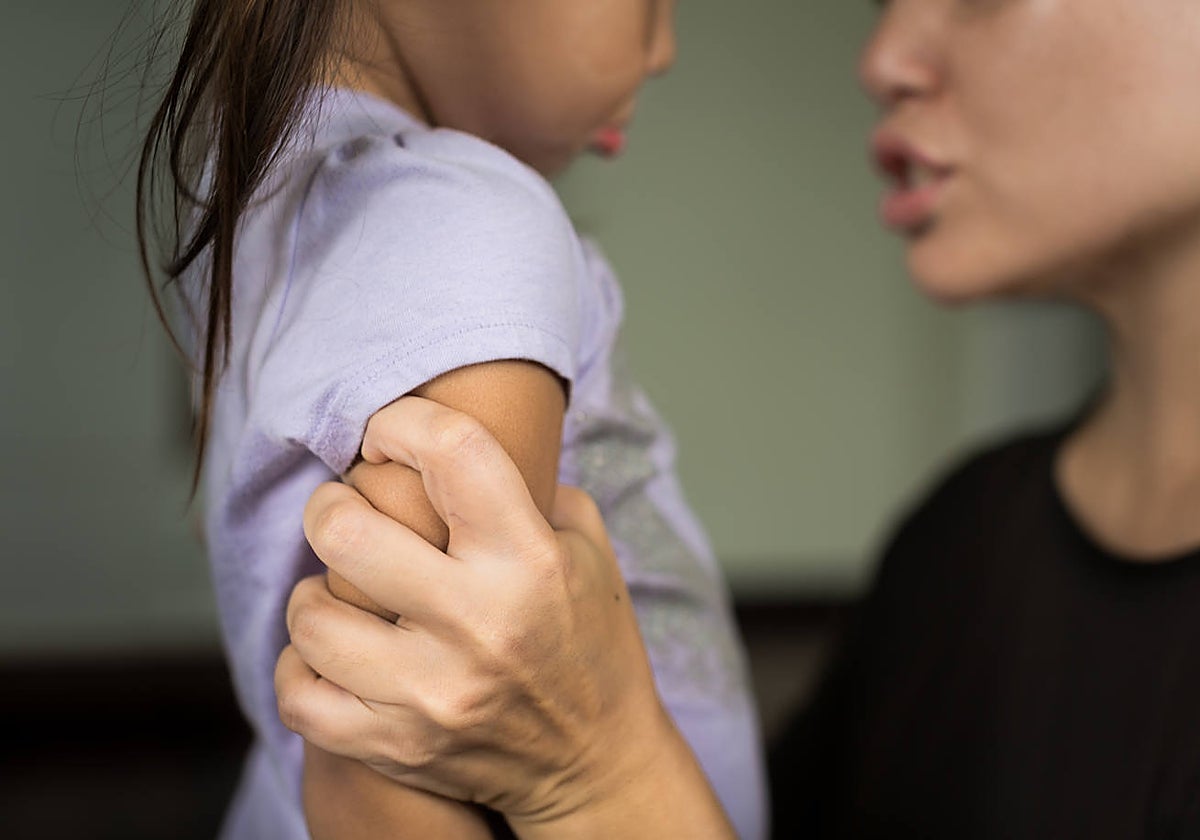 Una mujer zarandea a una niña