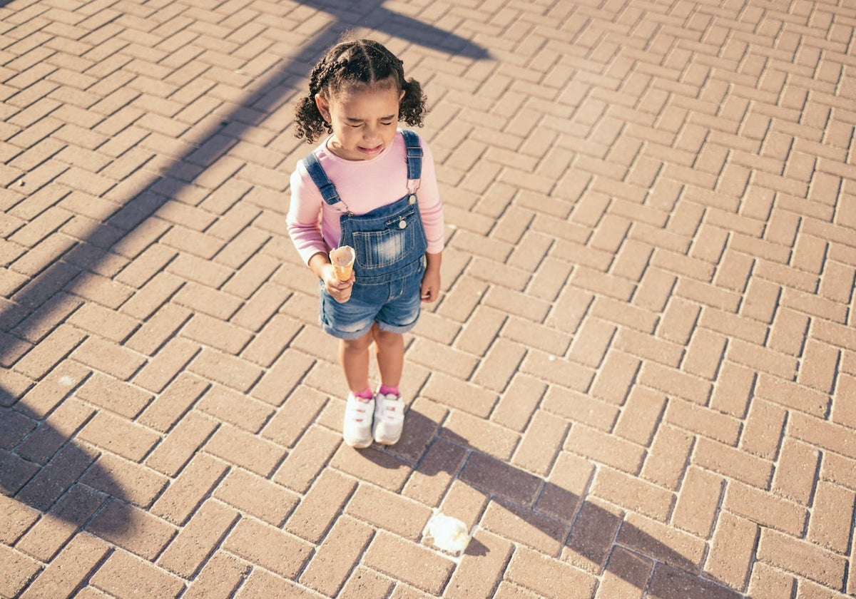 Una niña se lamenta ante el helado caído al suelo. Probablemente no sea una buena idea recuperarlo