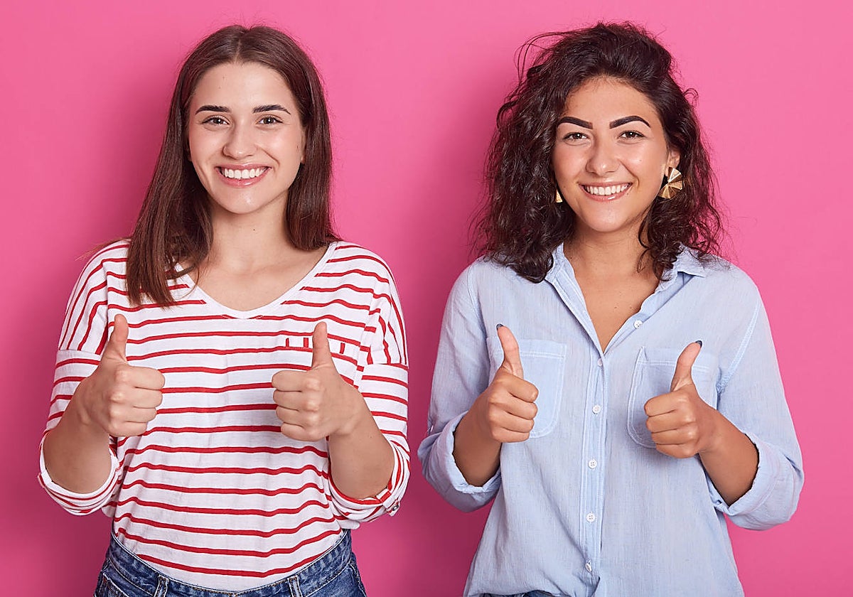 Una joven con el pelo liso y otra con el pelo rizado
