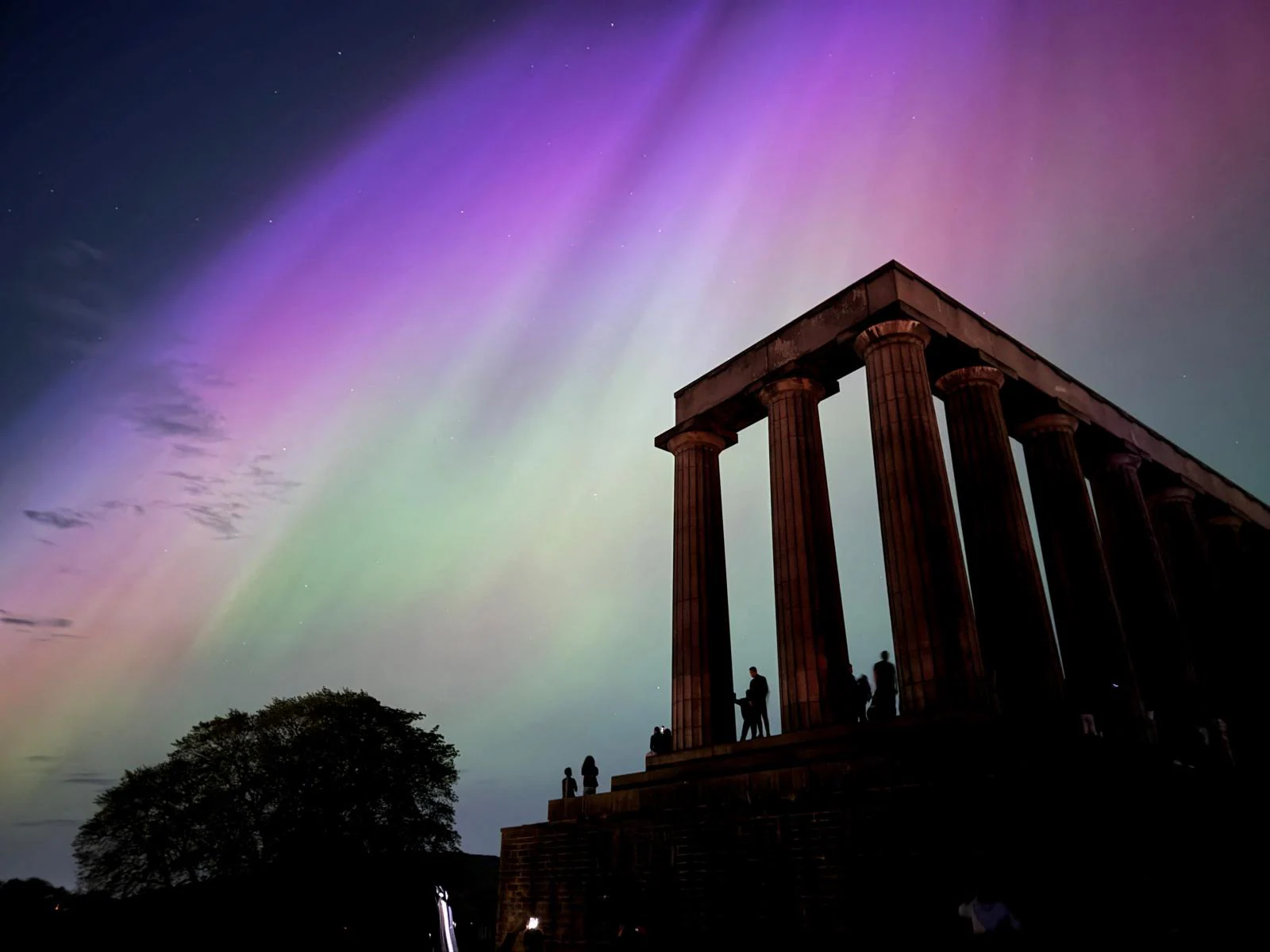 La aurora boreal durante una tormenta solar sobre el Monumento Nacional de Escocia en Edimburgo