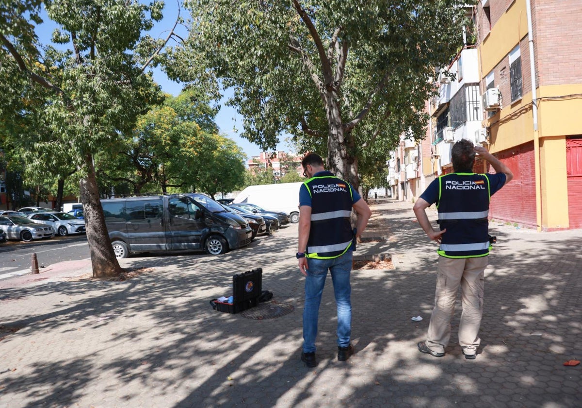 Dos agentes de Policía Científica inspeccionan la esquina donde se produjo el tiroteo