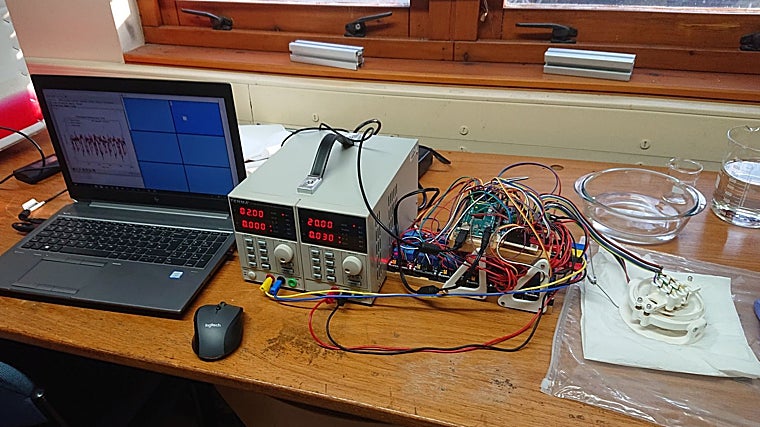 El dispositivo: a la derecha, en blanco, el sistema 'sandwichera' donde se introduce el hidrogel. En el centro, el equipo de cableado que traduce los cambios en el hidrogel y que, finalmente, se dirigen al ordenador, donde se juega al Pong