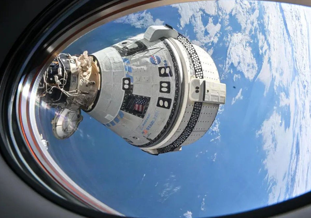 La nave Starliner atracada en la ISS y vista desde una de sus escotillas