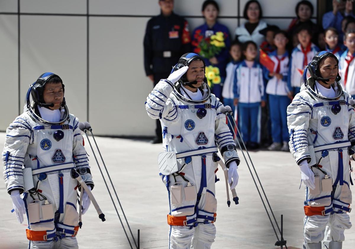 El comandante de la misión espacial Shenzhou-20, Chen Dong, saluda flanqueado por los coastronautas Chen Zhongrui (d), y Wang Jie durante la ceremonia de despedida en el Centro de Lanzamiento de Satélites de Jiuquan