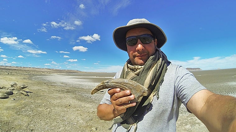 Un investigador sostiene la garra del megarraptor