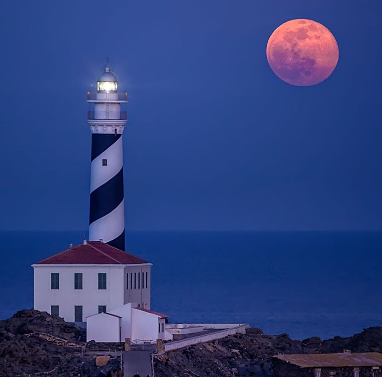 Farol Favarikh tendo como pano de fundo a lua cheia.