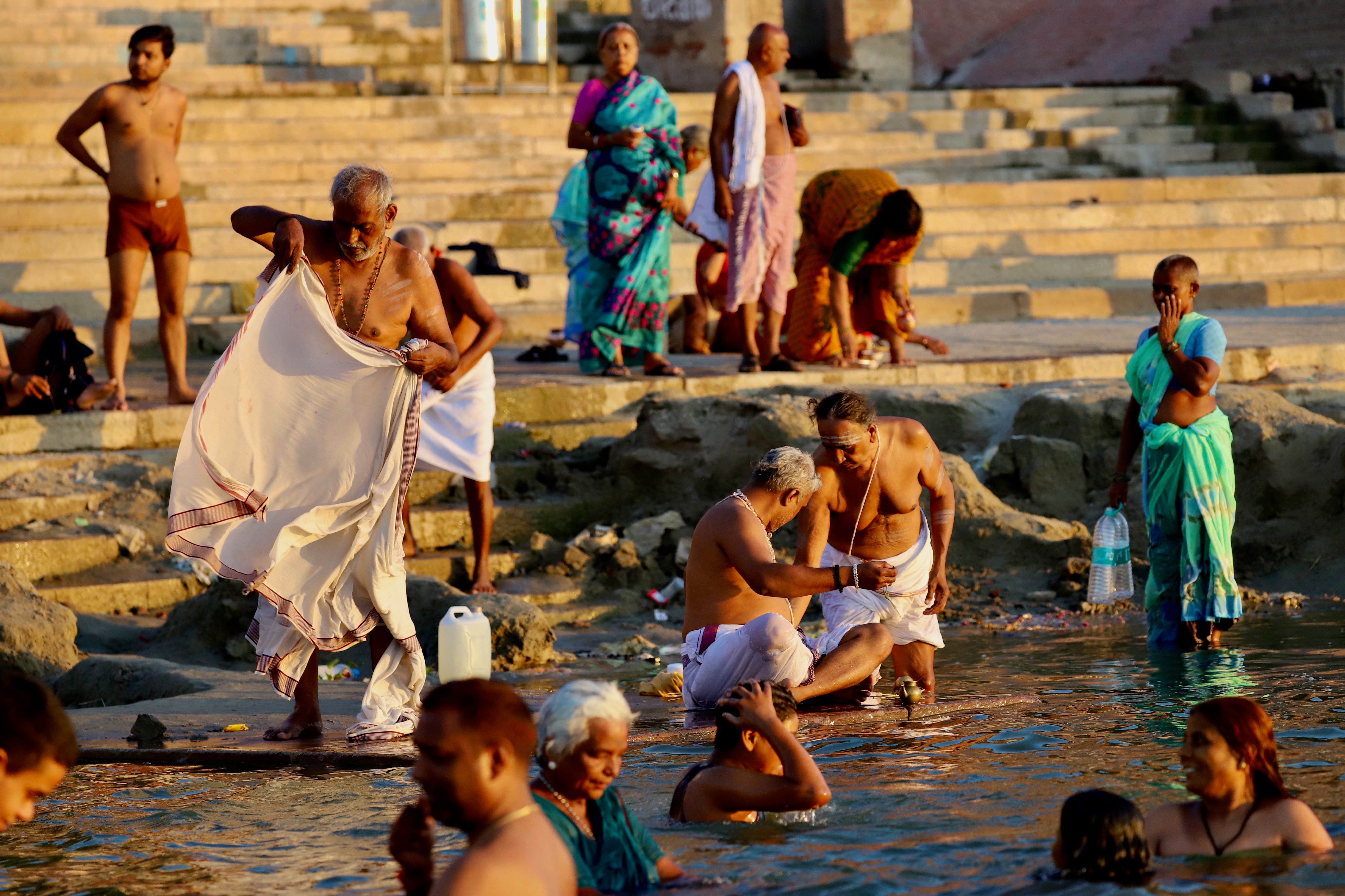 Hombres con pareos, mujeres con vistosos saris de colores y niños de reluciente piel morena se zambullen cada mañana en el Ganges