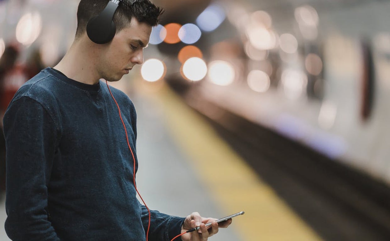 Un joven escuchando música en su «smartphone»