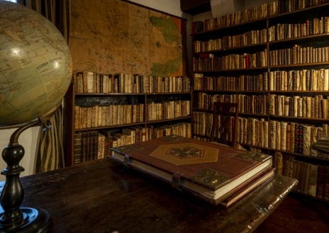 Imagen secundaria 1 - En la parte superior, vista general de una de las salas rodeada por una librería. Arriba, a la izquierda, rincón de la biblioteca que compartieron Pío Baroja y Julio Caro Baroja; a la derecha, estantes con cientos de ejemplares de las más variadas disciplinas; Antropología, Historia, náutica...