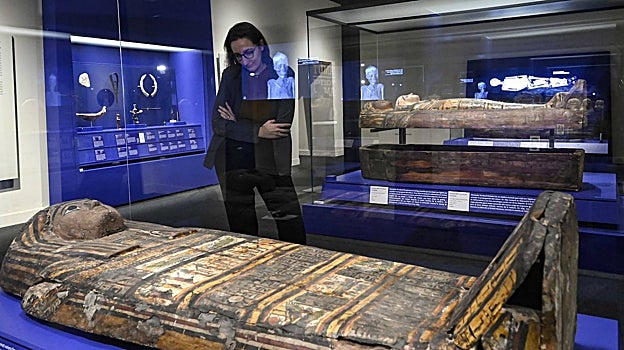 Una visitante observa uno de los sarcófagos de la exposición
