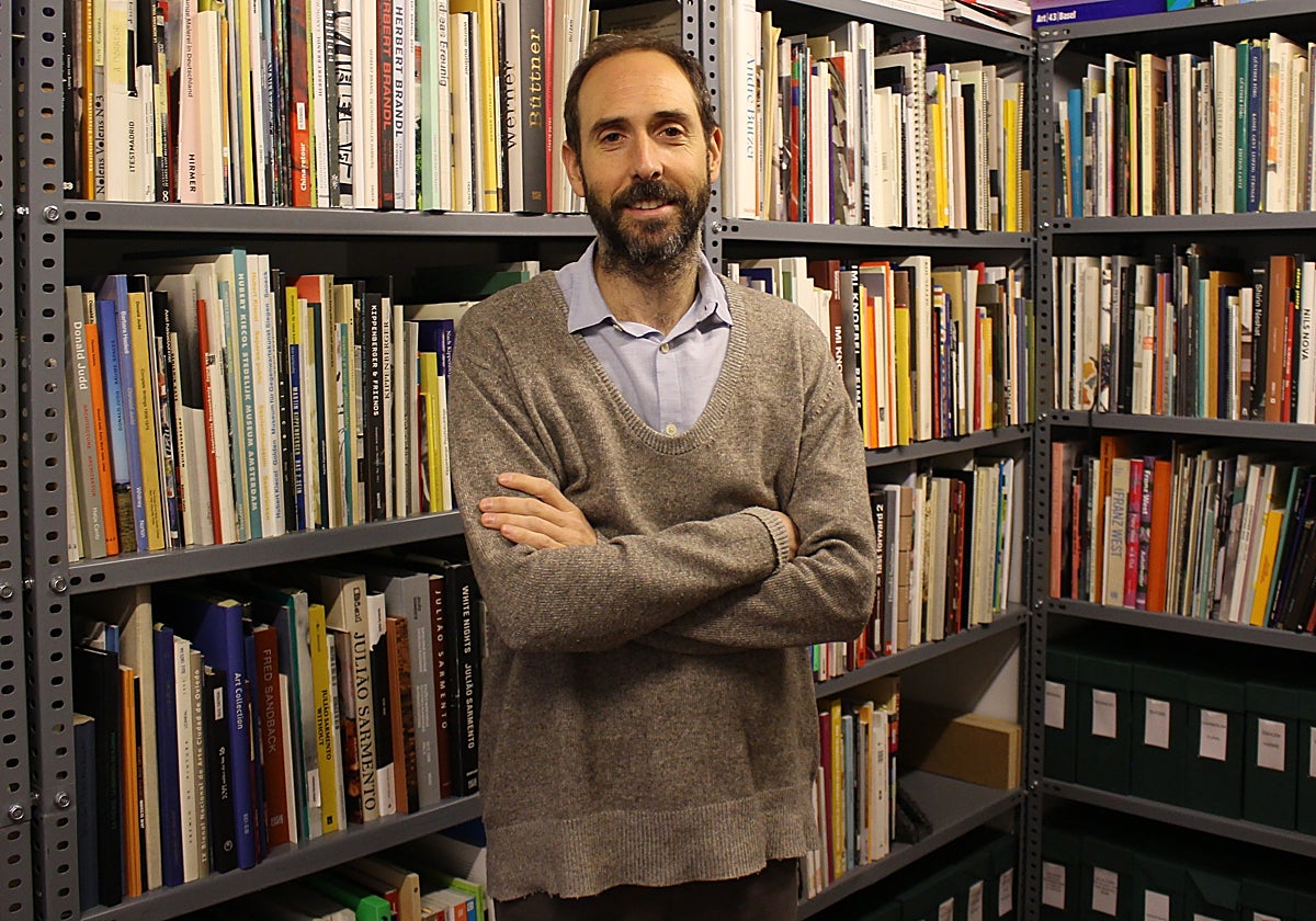 Pablo Flórez en su galería junto a su colección de libros de arte
