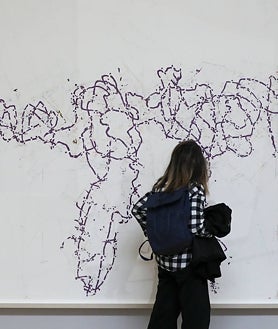 Imagen secundaria 2 - En la parte superior, Roni Horn delante de una sus piezas, 'LOG' compuesta por 406 láminas dibujadas por ella misma y que funcionan como un registro diario de observaciones y sucesos. Arriba, de izquierda a derecha, detalle de 'a.k.a', un panel de 15 pares de retratos de la artista, extraídos de archivos personales, y fragmento de otra de sus obras expuestas