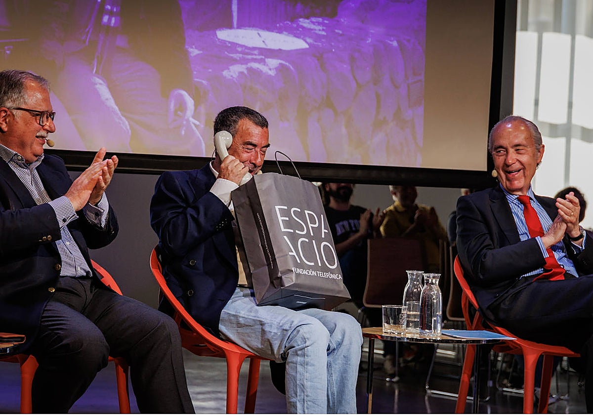 José Luis Garci abre un regalo de Chema Alonso ayer durante el homenaje que le rindieron en la fundación Telefónica por los 40 años del Oscar a 'Volver a empezar'. Le acompañan Luis Herrero y Luis Alberto de Cuenca