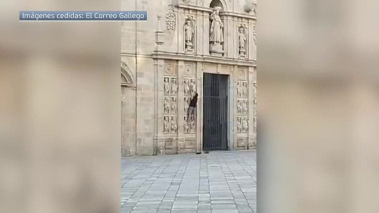 Un hombre se encarama a la fachada de la Puerta Santa en la catedral de Santiago