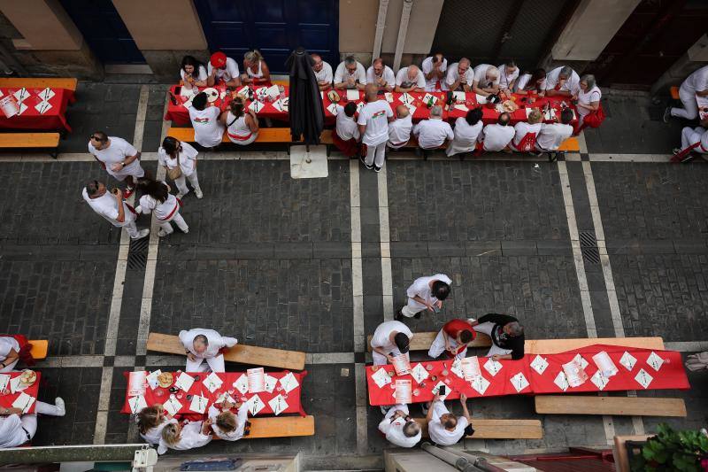 Varias personas celebran el tradicional almuerzo previo al comienzo de los Sanfermines en Pamplona