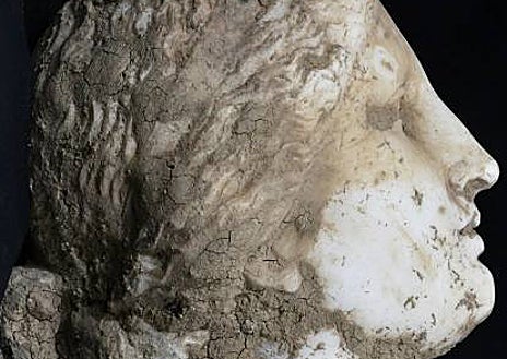 Imagen secundaria 1 - La cabeza se encontró en los cimientos de un muro antiguo, reutilizada como material de construcción. Una práctica común en la Baja Edad Media, que permitió conservar muchas obras de arte 