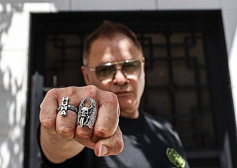 Imagen secundaria 1 - Chimo Bayo cortando el bacalao en la primera foto. En la segunda, muestra su anillo 'hu-ha'; en la última, con el dueño del restaurante 'El rey del bacalao'