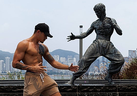 Un visitante posa frente a la estatua de Bruce Lee en Hong Kong, en el muelle de Tsim Sha Tsui