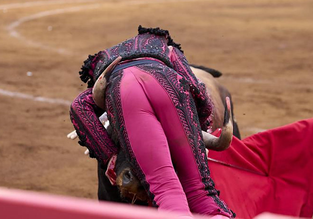 Roca Rey, entre los pitones del sexto toro, que lo estampó contra las tablas