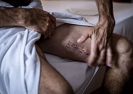 Imagen secundaria 1 - Paco Robleño, tío del matador y modo de espadas, le ayuda a vestir el humano miedo de valor de luces. Aún está reciente la cicatriz de los Sanfermines. Robleño pide silencio y extiende sus estampas sobre la cama. 